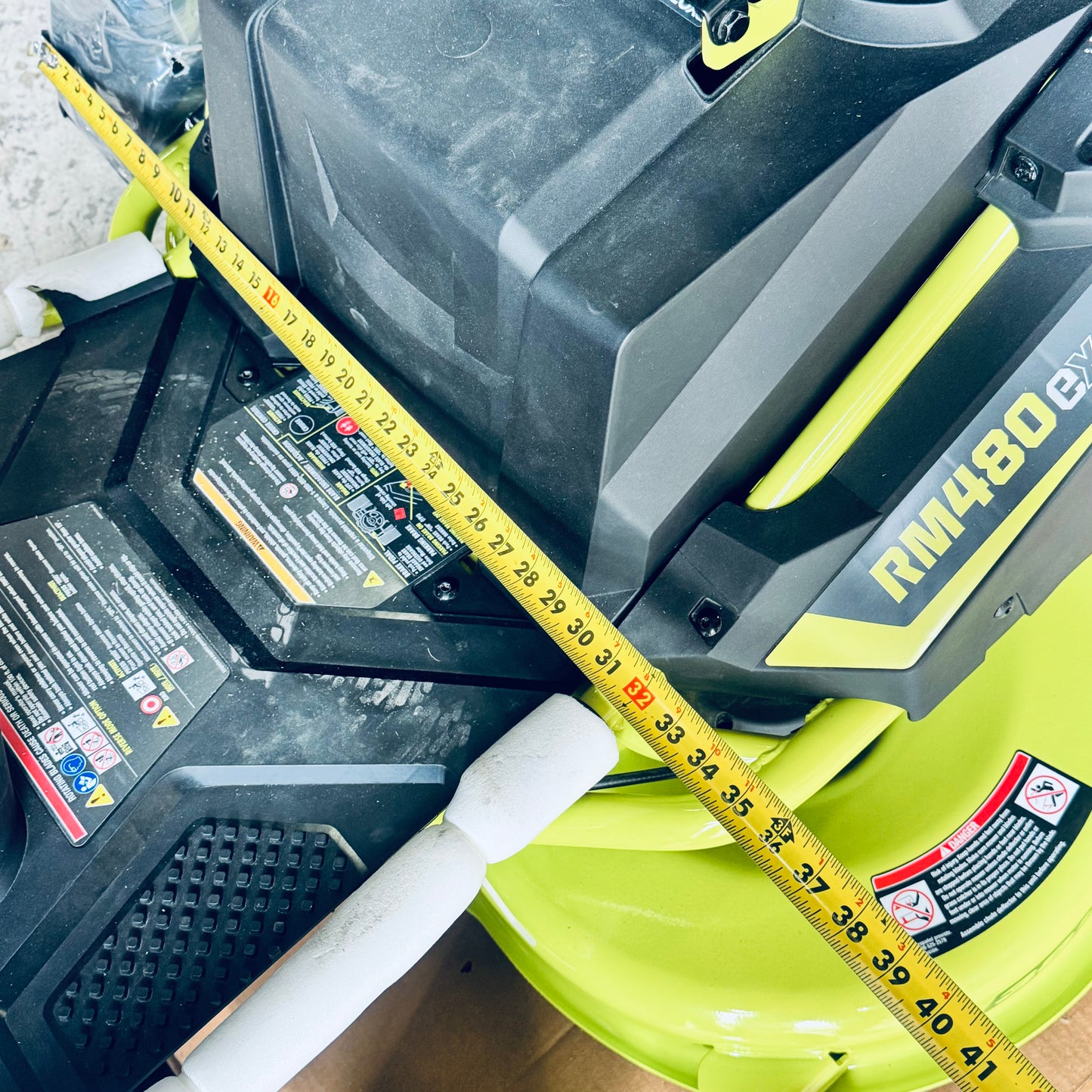 ZA@ RYOBI RYOBI 48V Brushless 38 in. 100 Ah Battery Electric Rear Engine Riding Lawn Mower Sz 64”Lx44”Hx41”W, Green & Black Color (AS-IS, Dinged Steering Wheel)