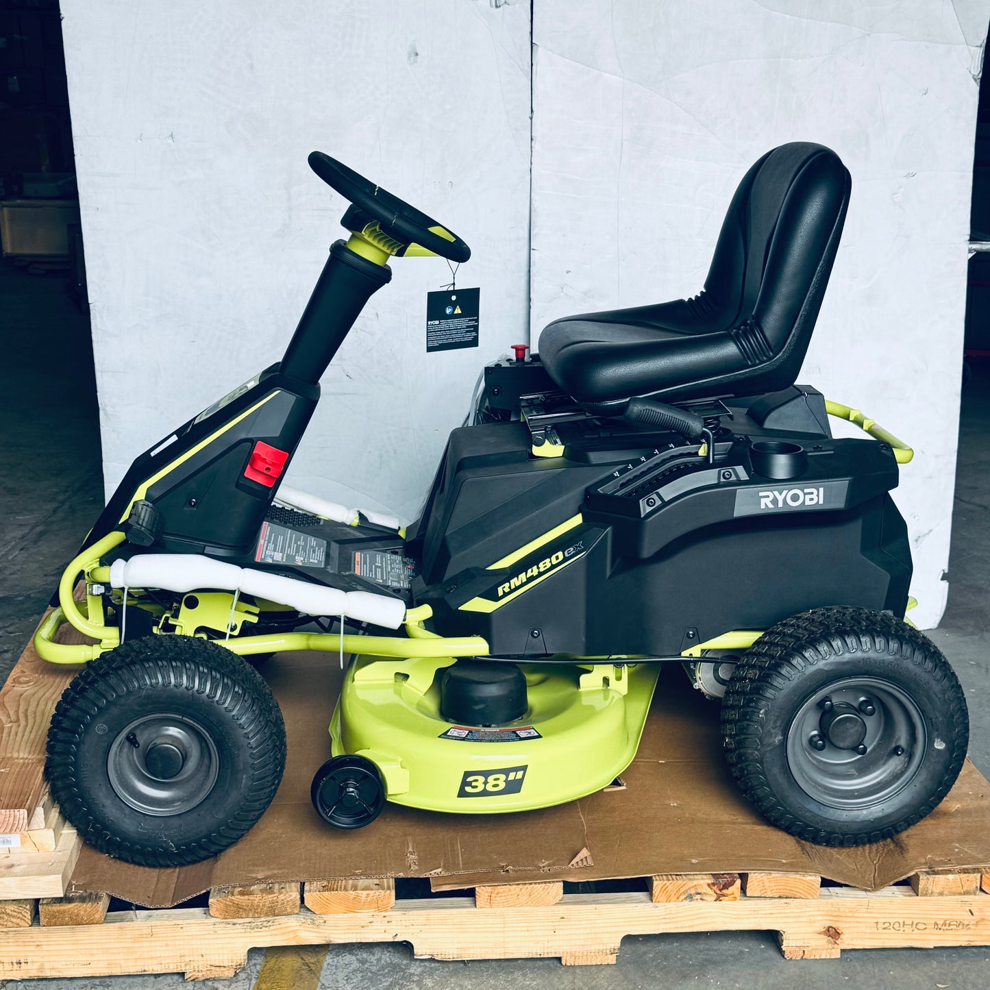 ZA@ RYOBI RYOBI 48V Brushless 38 in. 100 Ah Battery Electric Rear Engine Riding Lawn Mower Sz 64”Lx44”Hx41”W, Green & Black Color (AS-IS, Dinged Steering Wheel)