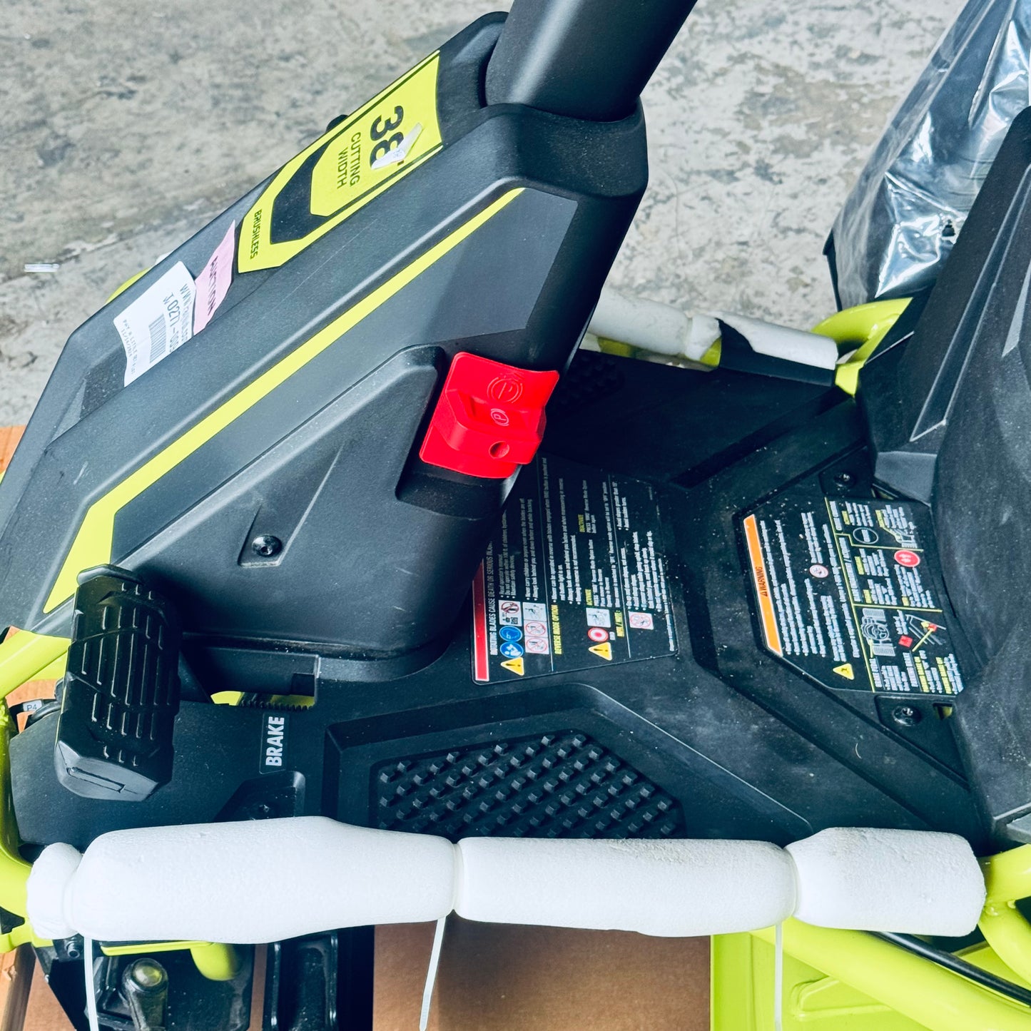 ZA@ RYOBI RYOBI 48V Brushless 38 in. 100 Ah Battery Electric Rear Engine Riding Lawn Mower Sz 64”Lx44”Hx41”W, Green & Black Color (AS-IS, Dinged Steering Wheel)