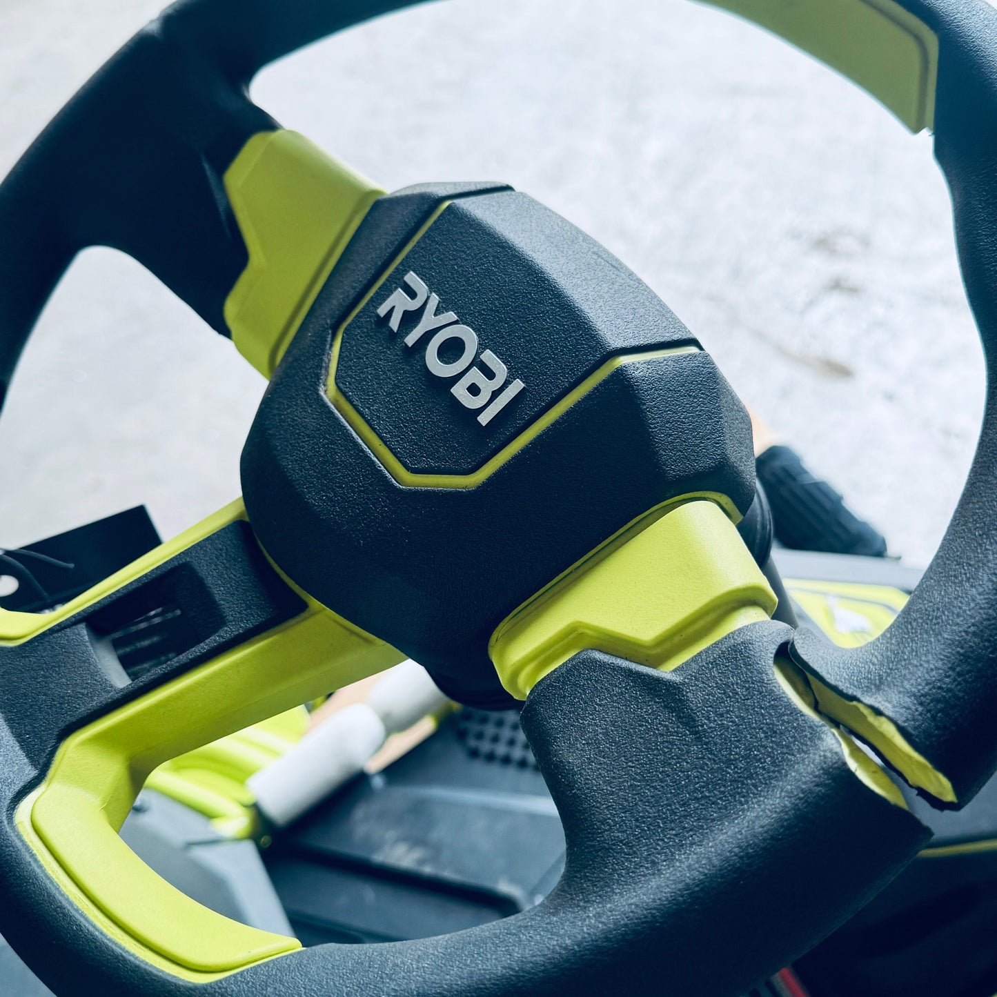 ZA@ RYOBI RYOBI 48V Brushless 38 in. 100 Ah Battery Electric Rear Engine Riding Lawn Mower Sz 64”Lx44”Hx41”W, Green & Black Color (AS-IS, Dinged Steering Wheel)