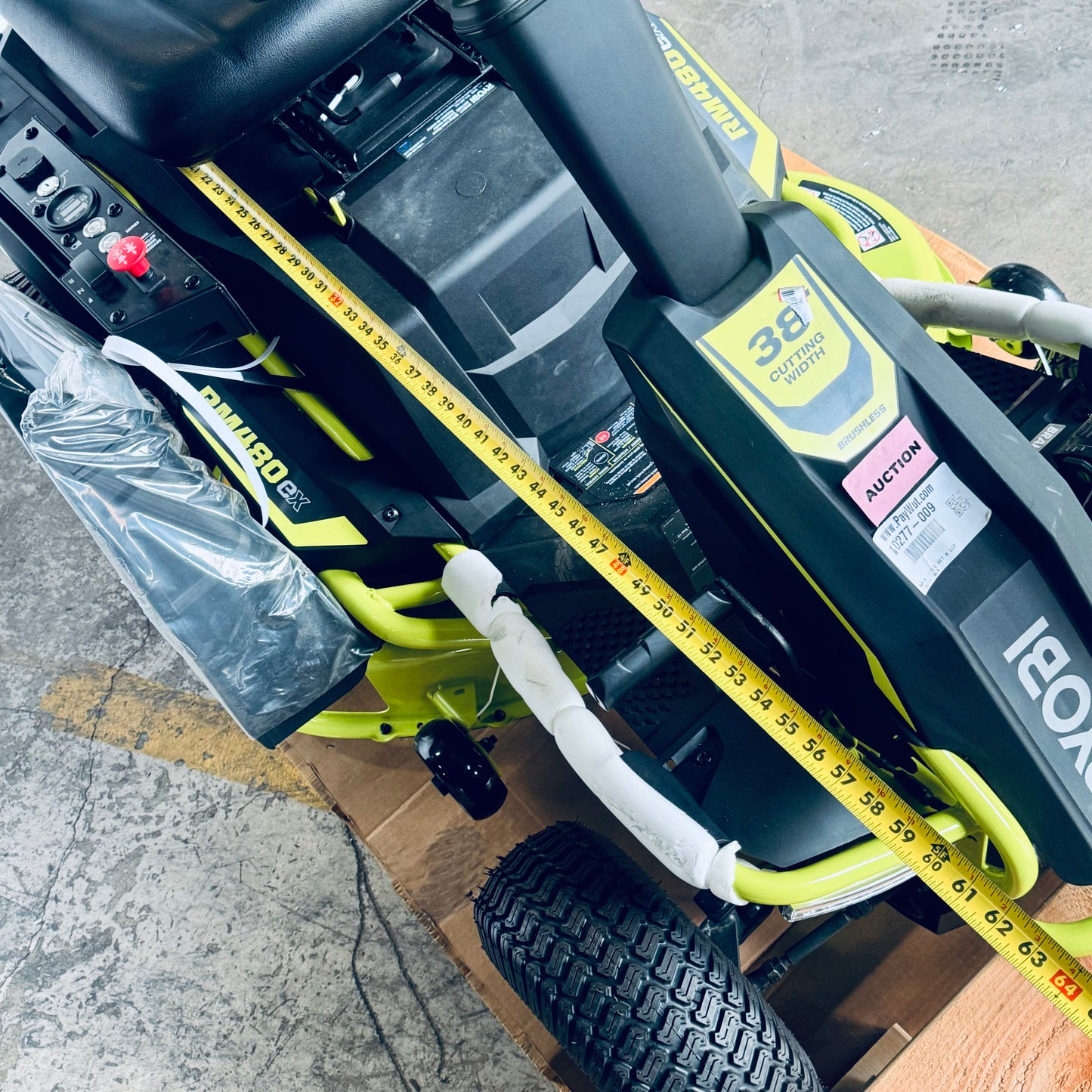 ZA@ RYOBI RYOBI 48V Brushless 38 in. 100 Ah Battery Electric Rear Engine Riding Lawn Mower Sz 64”Lx44”Hx41”W, Green & Black Color (AS-IS, Dinged Steering Wheel)