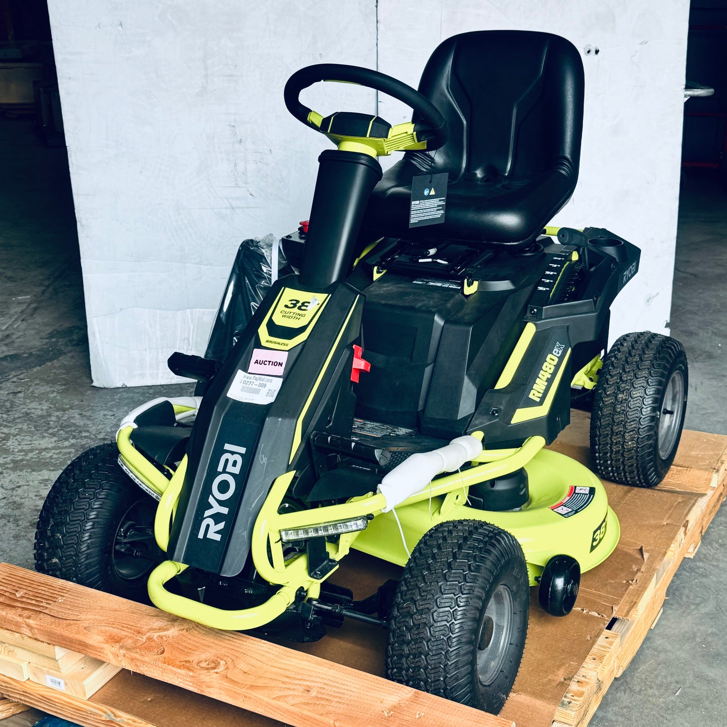 ZA@ RYOBI RYOBI 48V Brushless 38 in. 100 Ah Battery Electric Rear Engine Riding Lawn Mower Sz 64”Lx44”Hx41”W, Green & Black Color (AS-IS, Dinged Steering Wheel)