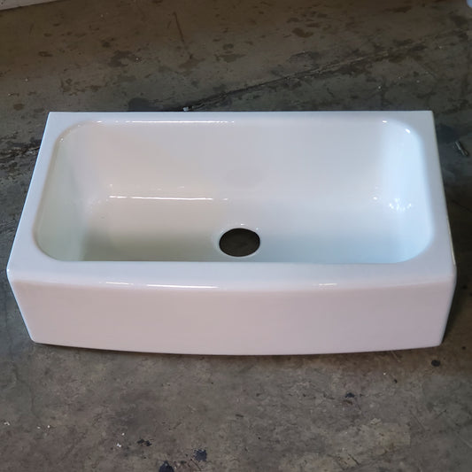 White ceramic sink on a concrete floor