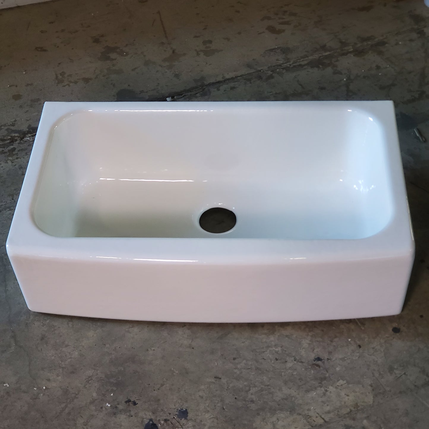 White ceramic sink on a concrete floor